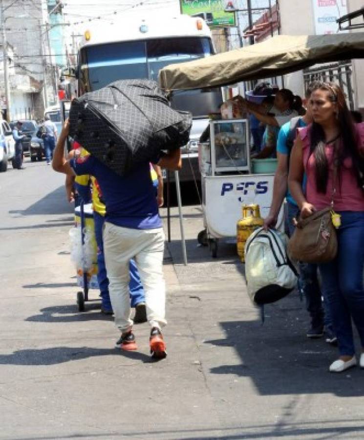 Con la maleta llena se observa a algunas personas que se dirigen a las terminales de buses en Comayagüela.
