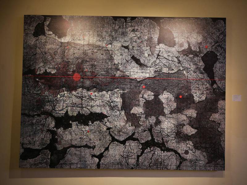 El cordel rojo y el color rojo es algo que se repite de manera simbólica en la obra del artista. El cordel es la representación de las tensiones sociales, políticas y de violencia que se viven en el territorio.