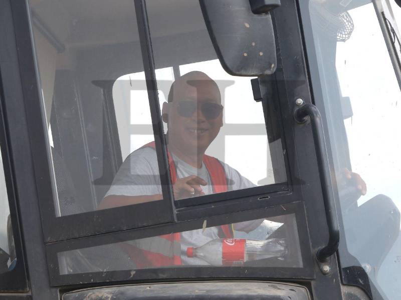 Uno de los empleados de la empresa China SFECO Group sonríe a la cámara de EL HERALDO Plus mientras conduce un tractor en medio de la construcción del nuevo Hospital del Sur.