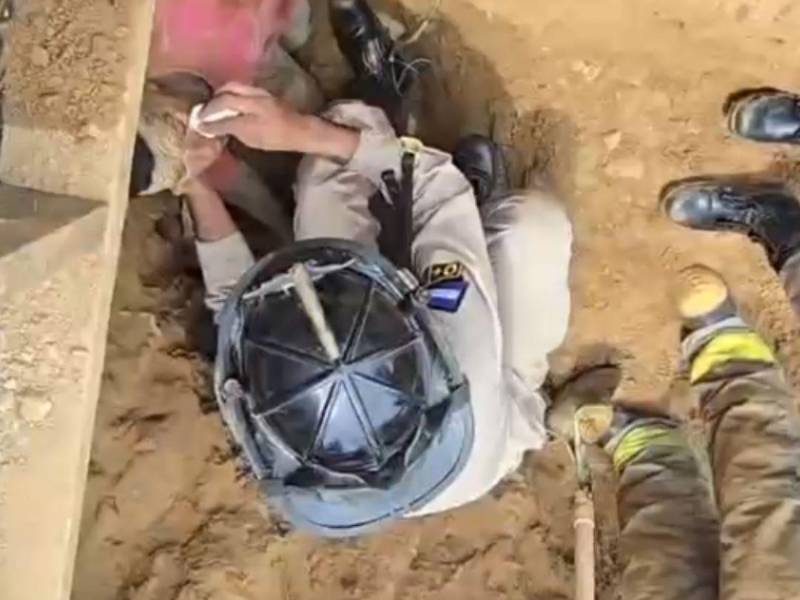 Momento en que el Cuerpo de Bomberos rescataba a una de las personas soterradas en Roatán.