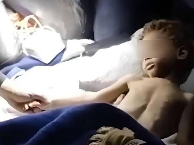 Sostienen la mano del pequeño identificado preliminarmente como Klieber Morán, mientras es atendido en una ambulancia tras lograr rescatarlo.
