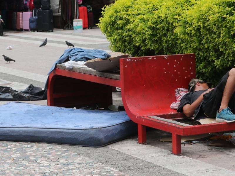 Colchones, cartones y ropa vieja cubren las bancas de la plaza, donde viven decenas de personas sin techo ante la vista y el temor de los capitalinos