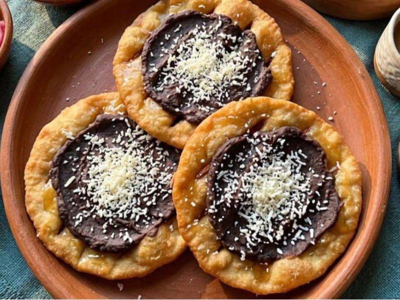 Una arriesgada propuesta culinaria: acompañar las macheteadas con frijoles y queso semejando una catracha.