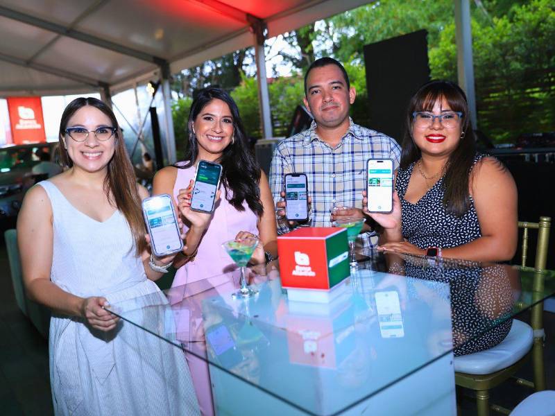 Invitados al evento muestran la app Puma Pris que descargaron en sus celulares para participar en esta promoción.