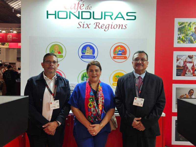 Representantes del sector cafetalero posan con orgullo frente al stand. El evento destaca el valor de las diferentes zonas productoras del país y su posicionamiento en los mercados internacionales