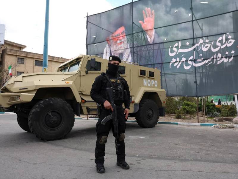 Un miembro de las fuerzas de seguridad iraníes monta guardia junto a una pancarta en honor al exlíder supremo iraní Ali Jamenei, en Teherán, Irán.