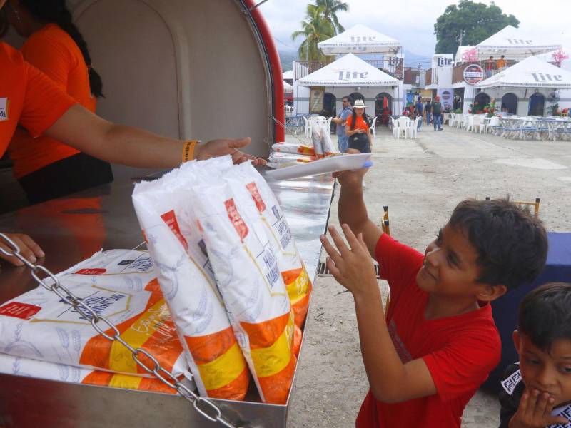 Un niño recibe con alegría la baleada de Harina Manhattan durante la celebración del Día Nacional de la Baleada