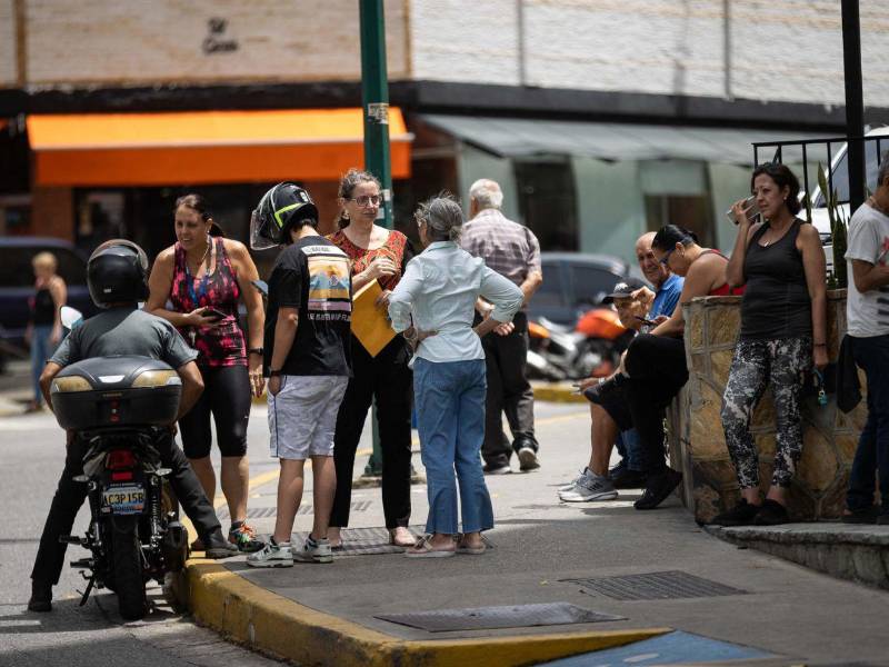 Personas esperan afuera de sus viviendas este viernes, luego de un temblor de magnitud 3.9, en Caracas, Venezuela.
