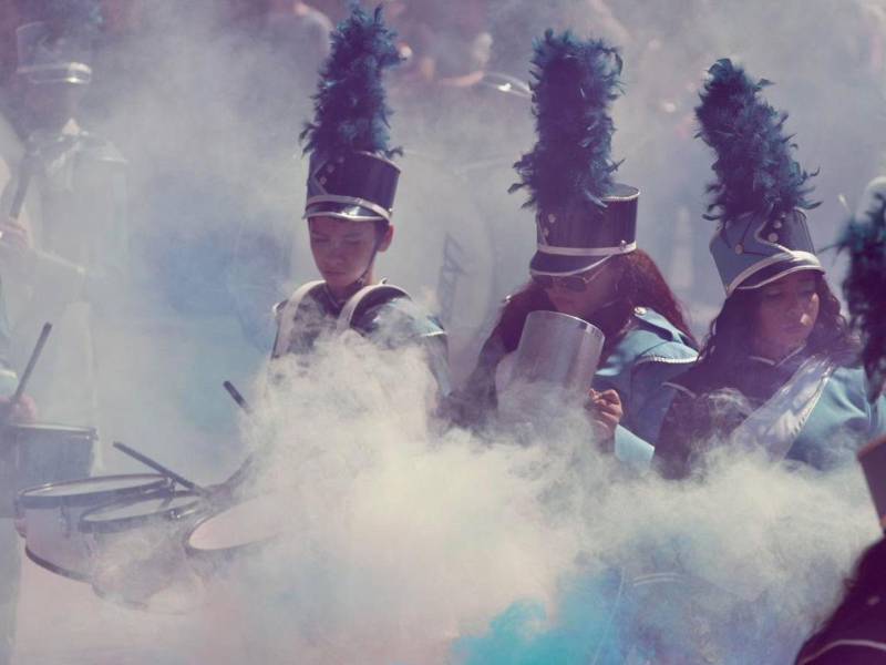 Como de película, entre humo pirotécnico, avanza la banda de guerra ofreciendo un majestuoso espectáculo musical para el público.