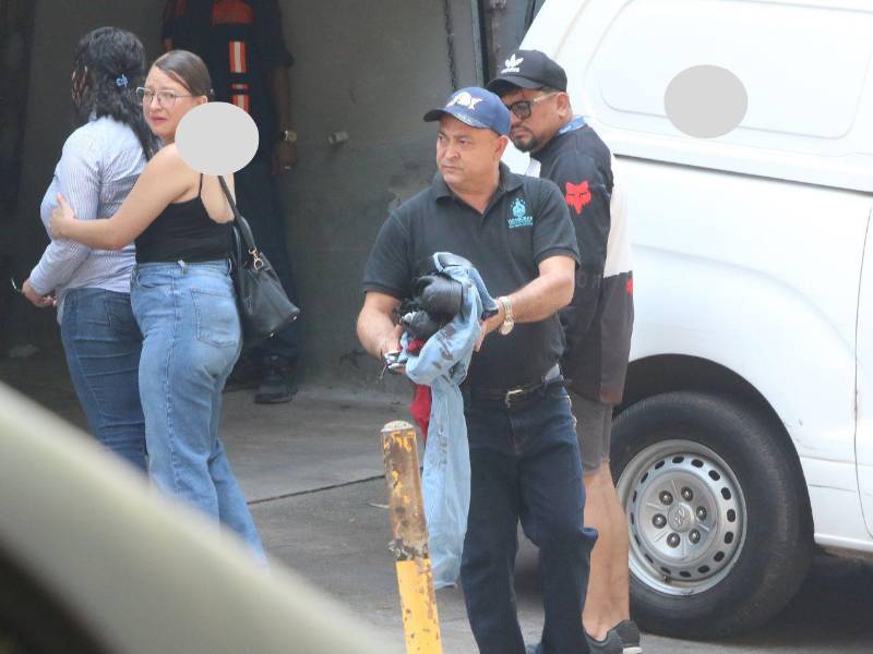 Don Samuel Juárez carga la ropa que su hijo José Manuel llevaba puesta ayer, mientras sus parientes retiran el cadáver de su vástago, en la morgue.