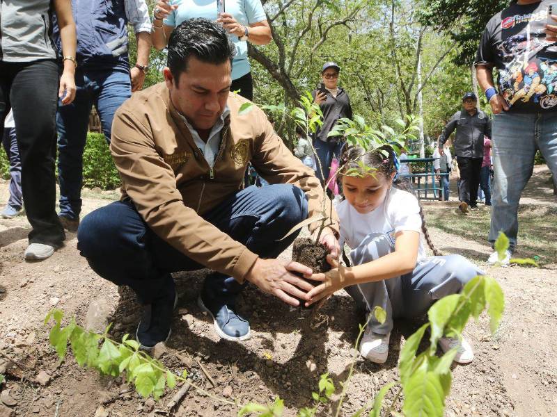 El alcalde Juan Diego Zelaya junto a la estudiante Paola Rodríguez, estudiante del CEB Roberto Sosa, plantando un árbol al que bautizó como Pulguita.