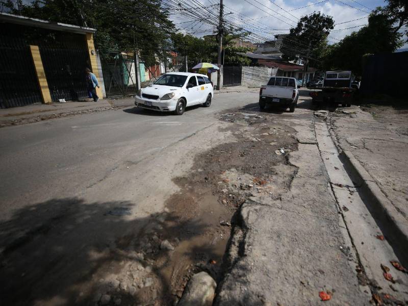 Vecinos de residencial Honduras denuncian baches y deterioro de la vía principal, mientras en El Dorado avanzan los trabajos de rehabilitación vial.