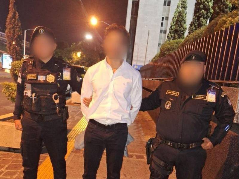 Agentes de seguridad custodian al hondureño detenido en el Aeropuerto Internacional La Aurora, en Guatemala, tras orden de captura con fines de extradición.