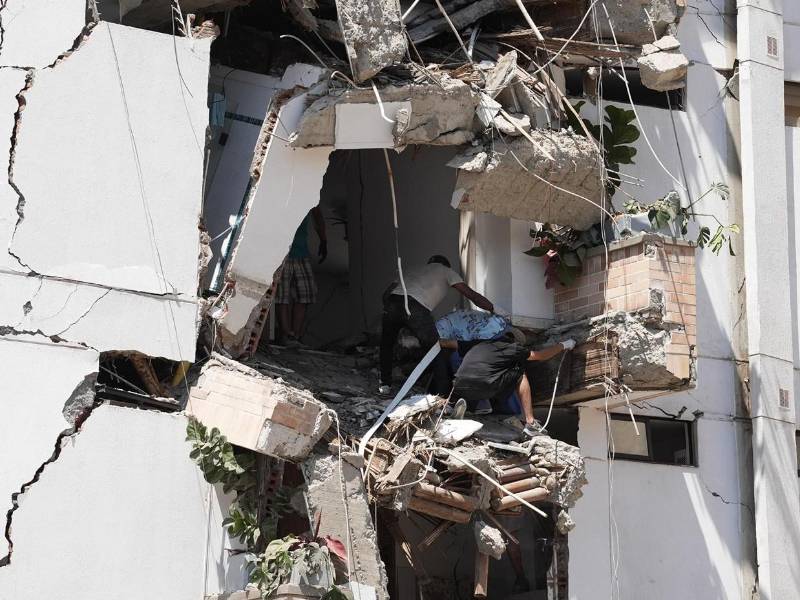 Al menos 20 edificios sufrieron graves daños por consecuencia del terremoto. Personas salen de los escombros de un edificio colapsado en el departamento del Valle del Cauca.