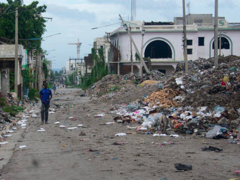 Un hombre camina por una calle del centro este sábado, mientras continúa la búsqueda de cuatro militares salvadoreños integrantes de la Fuerza de Supresión de Pandillas (GSF, sigla en inglés) desaparecidos tras sufrir una emboscada, en Puerto Príncipe (Haití).
