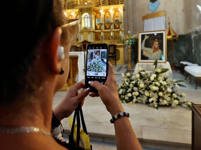 Una persona toma una fotografía de un cuadro con la imagen de la cantante cubana Celia Cruz durante una misa en su memoria este martes, en la iglesia de la Virgen de la Caridad, en La Habana.