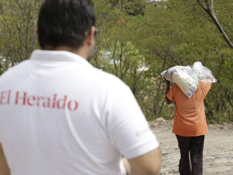 Algunas personas salían a la calle a buscar el automóvil de Diario EL HERALDO a pedir bolsas de comida.