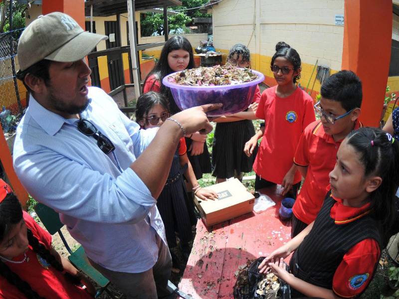 Estudiantes escuchan atentamente las instrucciones por parte de técnicos de la SERNA después de haber creado compostaje.