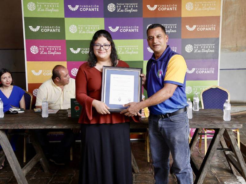 El poeta Néstor Ulloa hizo entrega a Valeria Cabrera de la placa del Premio Universitario de Poesía Amanda Castro.