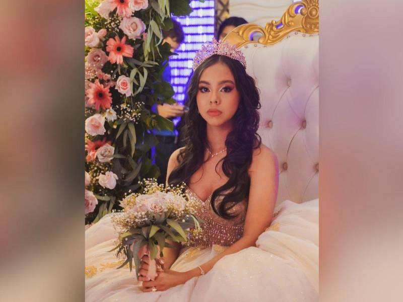 La quinceañera Alison Munguía, posa feliz ante la cámara, sentada en su trono de honor.