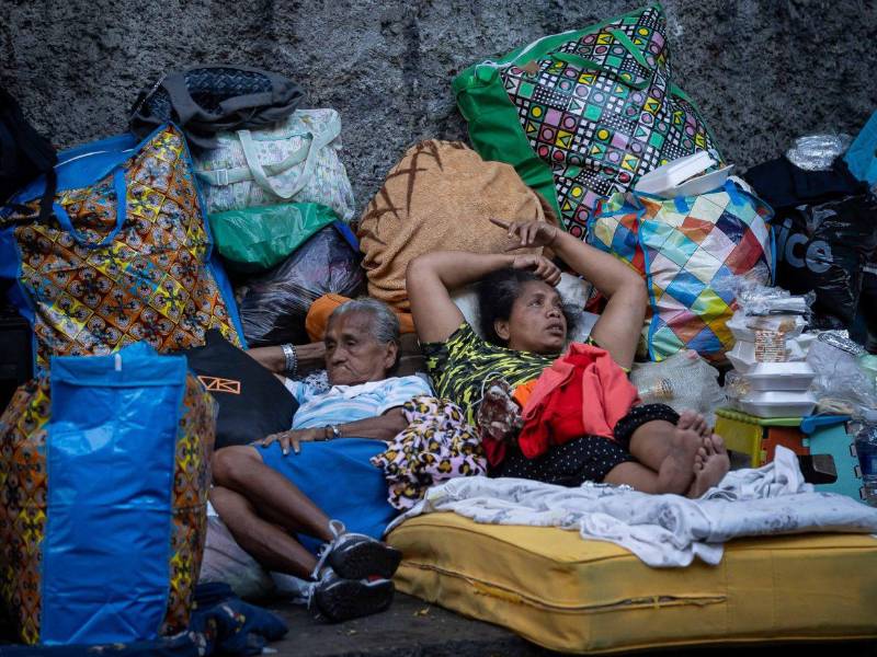 Personas esperan afuera de un edificio afectado por el terremoto, este sábado en Caracas. Las duras imágenes muestran la realidad que atraviesa Venezuela, donde familias deben dormir en la calle porque sus hogares se derrumbaron o por temor a nuevas réplicas.