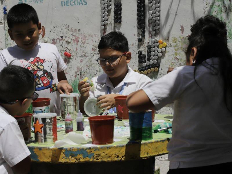 Los alumnos moldearon viejas latas de leche para transformarlas en alcancías con Nestlé y Vanguardia.