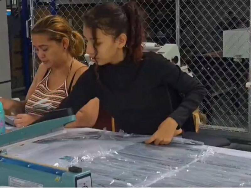 Personal del CNE prepara las cintas de seguridad que serán colocadas en las maletas electorales.