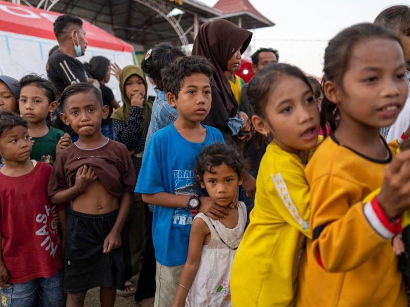 Personas evacuadas por un terremoto de magnitud 7,7 hacen fila para recibir alimentos en un refugio temporal en Maumere, en la provincia de Nusa Tenggara Oriental.