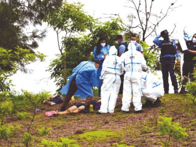 Equipos de investigación policial reconocen el cadáver de una mujer que fue asesinada en el municipio de Balfate, Atlántida, para determinar las causas y responsables del femicidio.