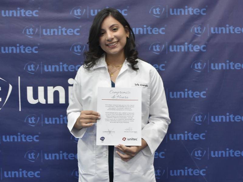 La estudiante de UNITEC Sofia Alvarado muestra el Compromiso de Honor que hicieron en la ceremonia y que lo llevarán en su memoria.