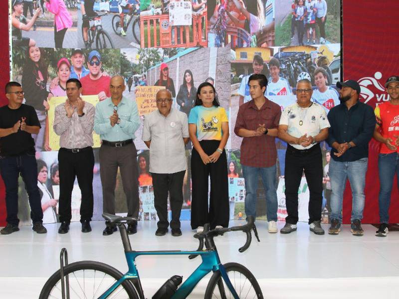 El sacerdote católico, Ovidio Rodríguez, junto a los ciclistas que fueron homenajeados en el lanzamiento de la XV Edición de la Vuelta Ciclística EL HERALDO 2026.