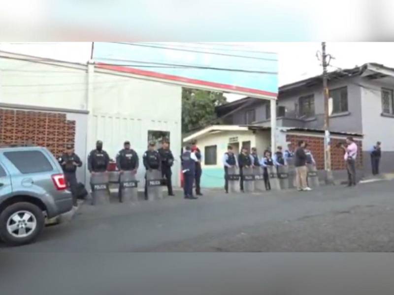 Varios agentes policiales resguardan la enttada principal de la SIT.