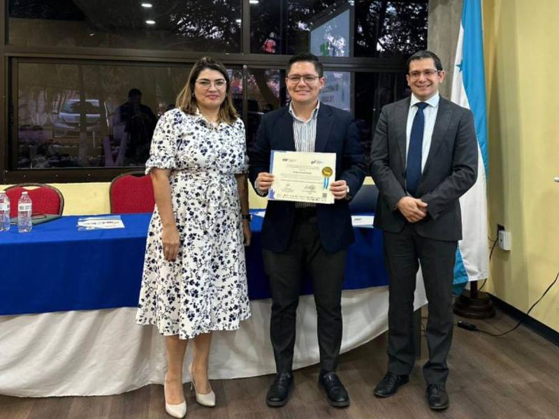 Viviana Casco Molinas, representante del CAF en Honduras y Jinmy Bertrand, director del IINTEC, entregan su diploma a uno de los graduados.