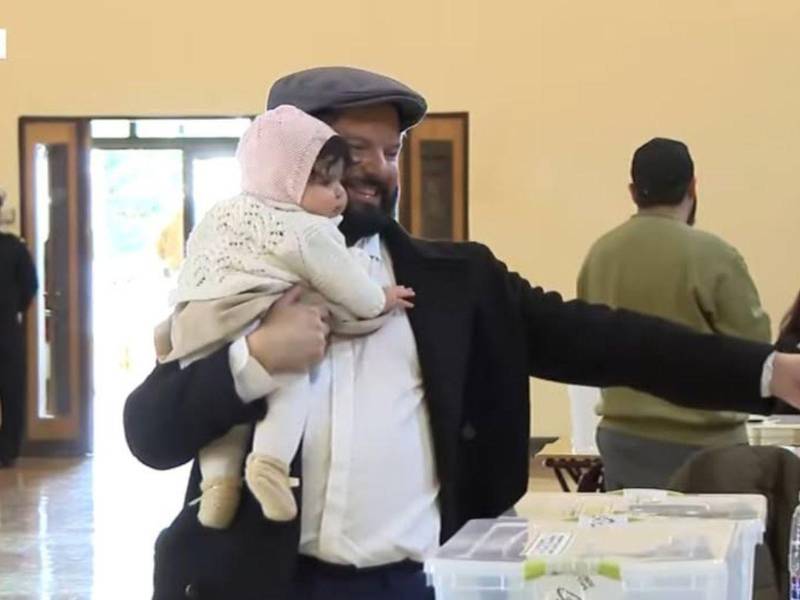 El mandatario llegó acompañado de su padre y cargando en brazos a su hija recién nacida, Violeta, mientras saludaba a los ciudadanos que esperaban en fila bajo un clima soleado.