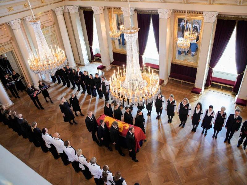El féretro del rey Harald V de Noruega es trasladado desde el Salón Rojo a la Capilla del Palacio, acompañado por miembros de la familia real y el personal de la corte.