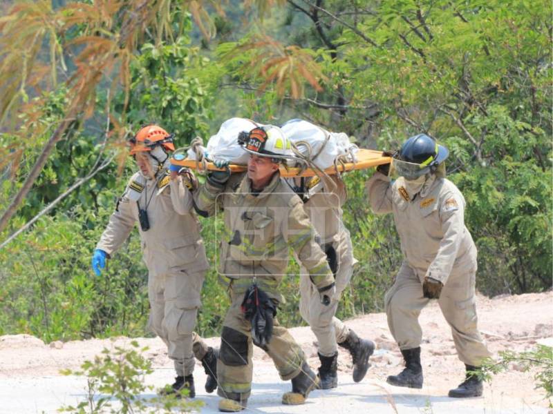 Miembros del Cuerpo de Bomberos de Honduras descendieron hasta un pequeño abismo de aproximadamente 75 metros para rescatar los tres cuerpos carbonizados que fueron hallados la mañana de este martes 12 de mayo, en una zona boscosa del cerro de la aldea El Cimarrón, en Francisco Morazán.
