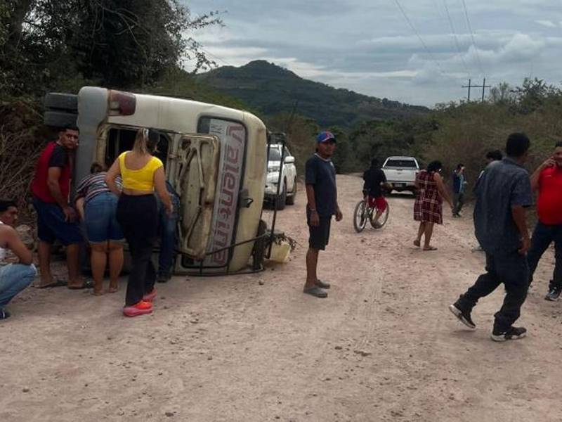 El autobús quedó volcado de lado en la carretera de tierra.