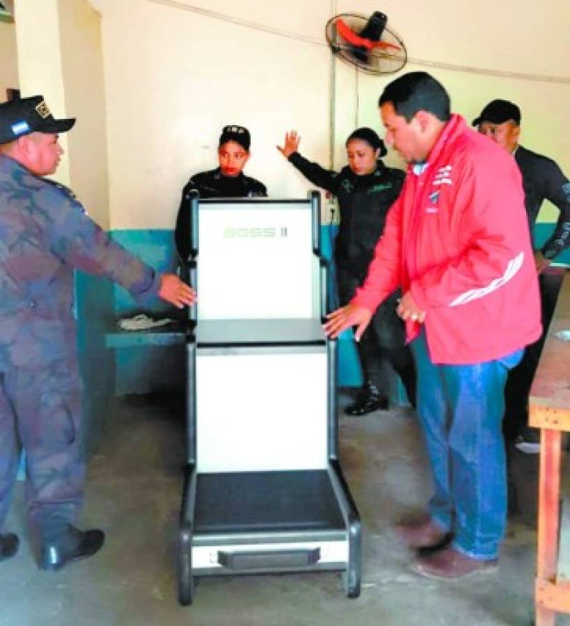 Las autoridades de la Penitenciaría de Comayagua mientras revisaban la instalación de la silla escáner en el ingreso a las instalaciones.