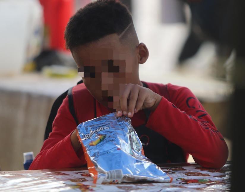$!Después del desayuno, este niño cubano decidió comerse un churro mientras esperaba ser atendido en el INM de Trojes, El Paraíso.