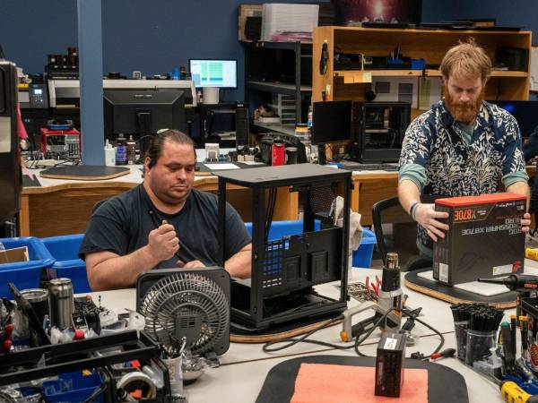 From left, assembly technicians Brian Hubbard and Jarett Kubli work in the production room at Falcon Northwest in Medford, Ore., Jan. 21, 2026. Falcon Northwest builds personal computer systems for gamers and others who are willing to pay $4,000 and more for extreme performance. (Loren Elliott/The New York Times)