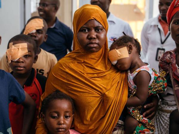 Muanema Fakira sostiene a Sumaya mientras esperan con otros para sus chequeos en el Hospital Central de Quelimane.
