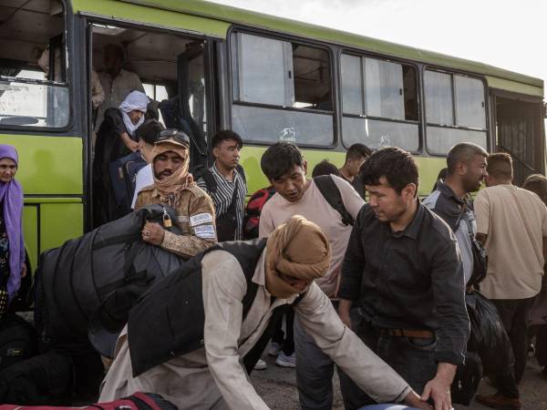 Dos millones de afganos han sido expulsados de países como Irán. En la frontera, un talibán ayuda a repatriados. (Jim Huylebroek para The New York Times)