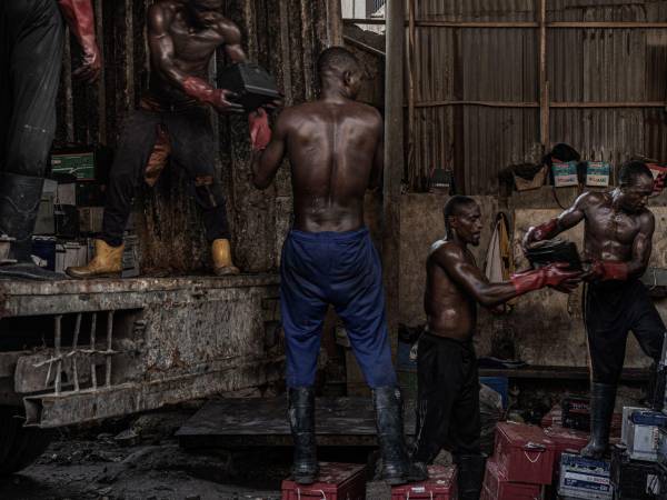 Cargando baterías de coche en un camión con destino a True Metals, una planta de fundición de plomo muy contaminada en Ogijo, Nigeria.