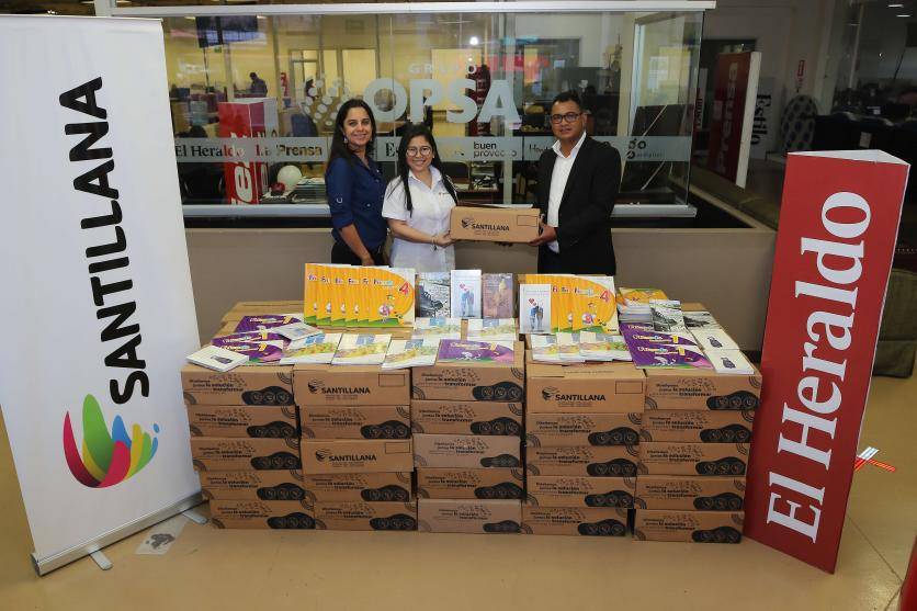Lorena Zavala, Coach educativo Senior y Melissa Ham, coordinadora de Marketing de Santillana Honduras, entregaron el donativo a Edwin Ordoñez, Editor de la sección Metro.