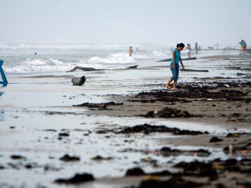 Turistas nacionales se aventuran a adentrarse en el mar picado en la Playa Bagdad, 38 kilómetros al este de Matamoros, estado de Tamaulipas (México).