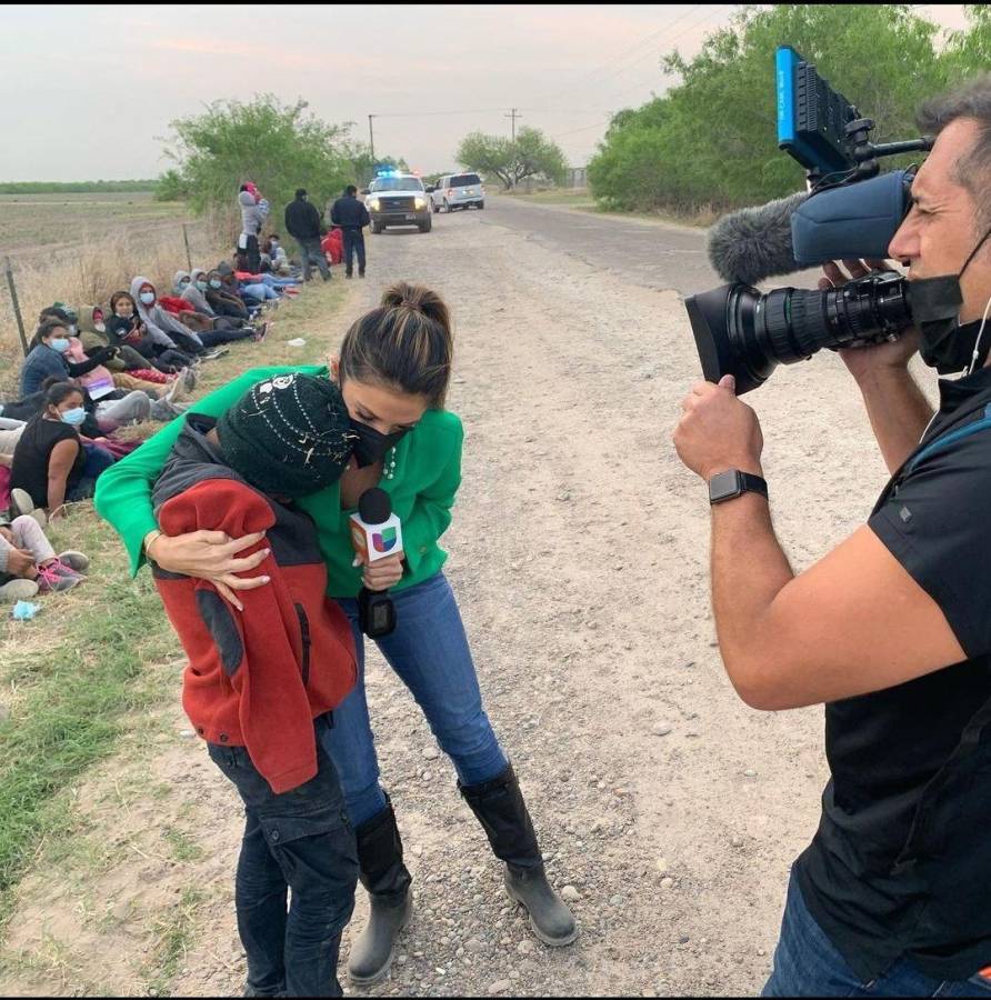 La periodista Maity Interiano abraza a Snyder, un niño que viajaba solo en la caravana de migrantes.