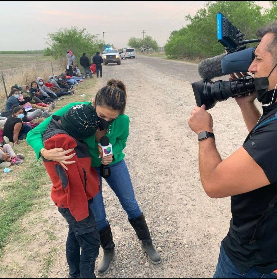 La periodista Maity Interiano abraza a Snyder, un niño que viajaba solo en la caravana de migrantes.