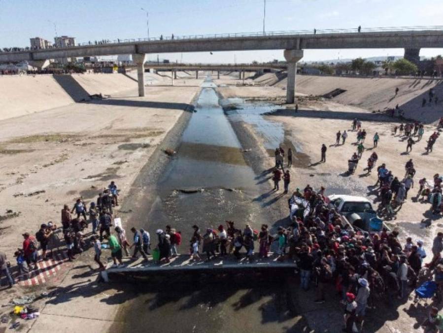 Fotos del momento en el que migrantes de la caravana saltaron valla fronteriza de Estados Unidos, pero fueron detenidos con gases lacrimógenos