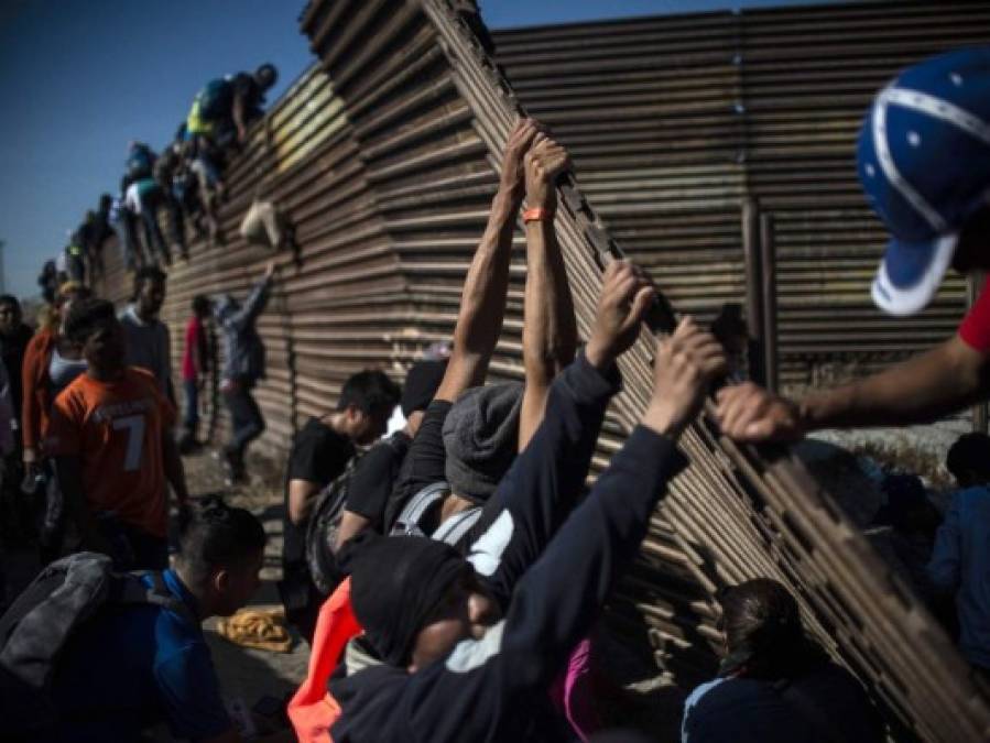 Fotos del momento en el que migrantes de la caravana saltaron valla fronteriza de Estados Unidos, pero fueron detenidos con gases lacrimógenos