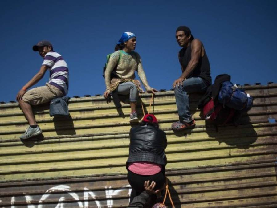 Fotos del momento en el que migrantes de la caravana saltaron valla fronteriza de Estados Unidos, pero fueron detenidos con gases lacrimógenos